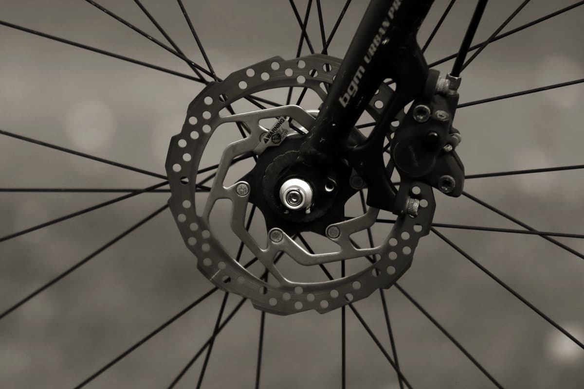 Close detail of a disc brake rotor and caliper on a bicycle wheel