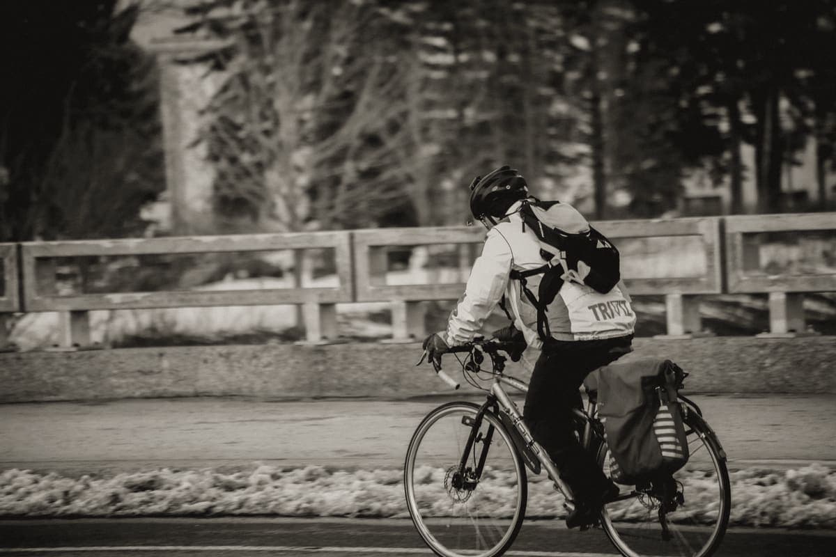 A rider in a jacket on a bicycle in cold, flat light
