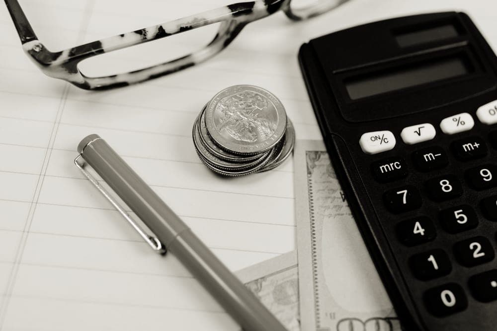 A calculator and coins on a desk