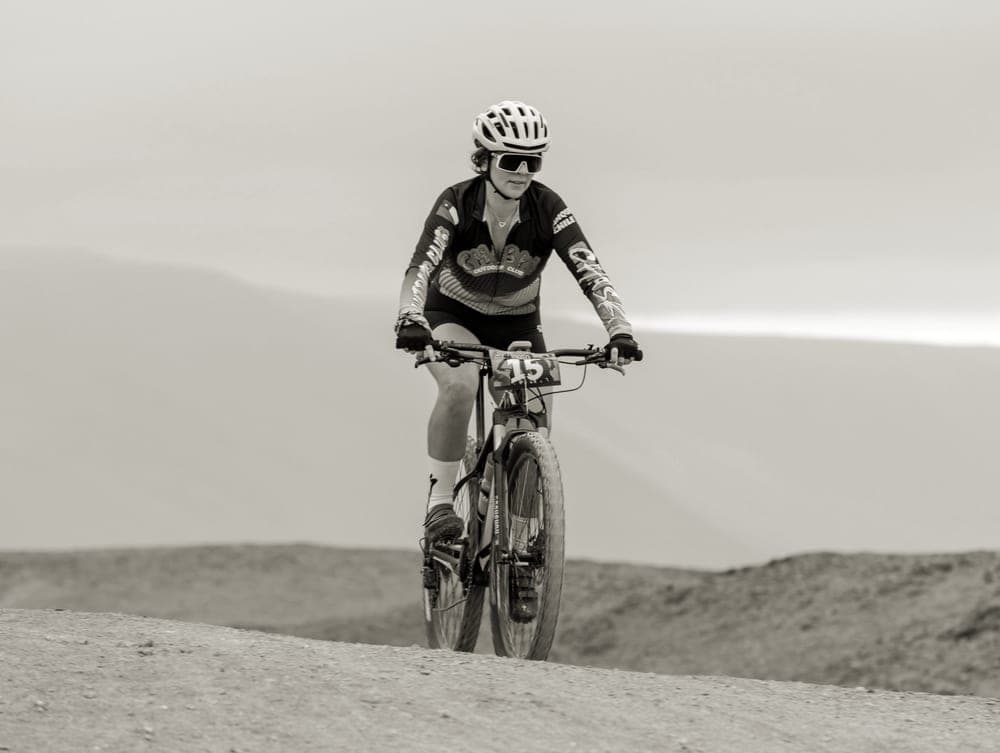 A rider racing a drop-bar bike on a dry off-road course
