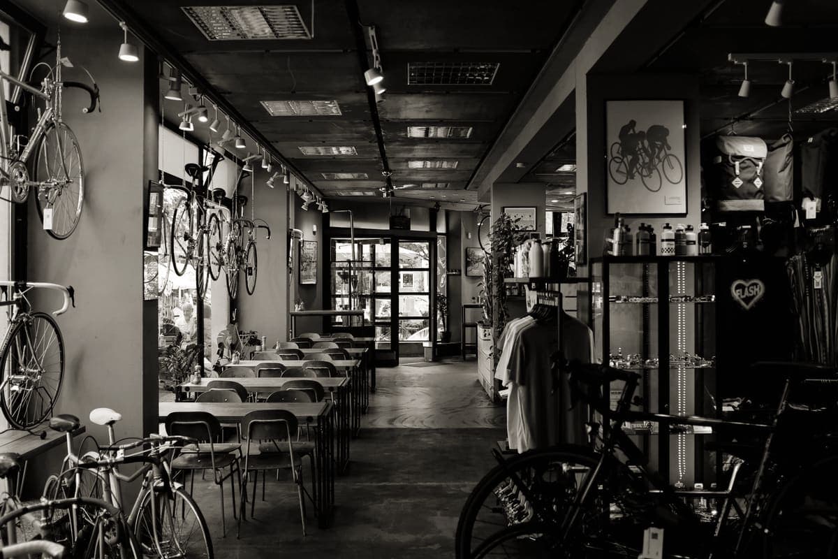 The inside of a bike shop with road bikes hung on the wall and accessories on display