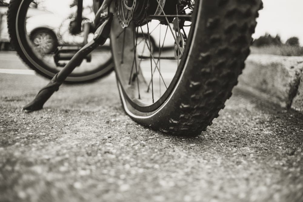 A flat bicycle tire resting on asphalt