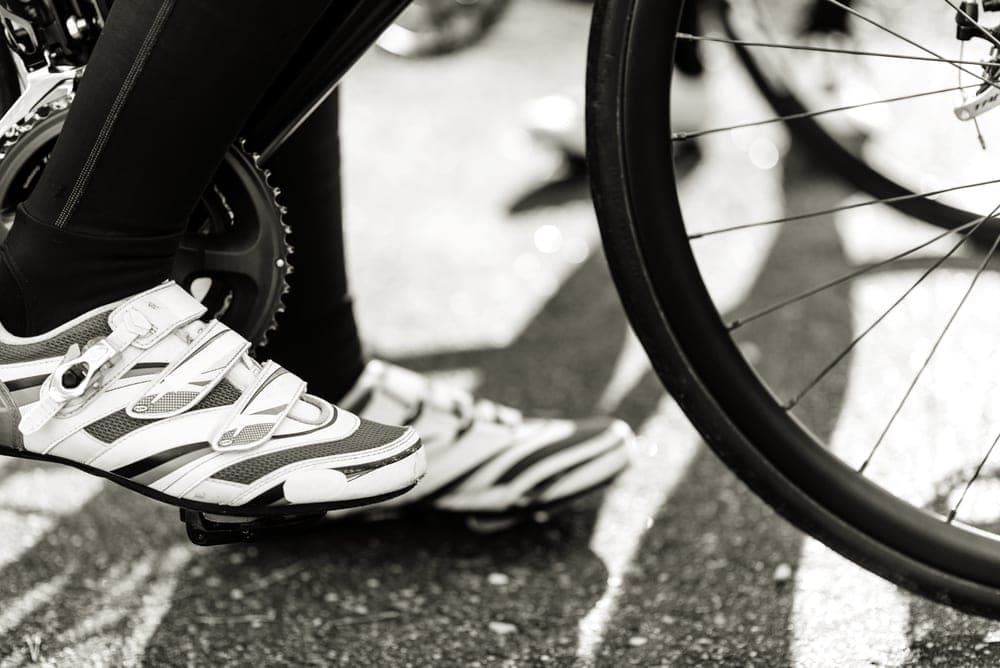 A cycling shoe cleated into a clipless pedal, seen from the side