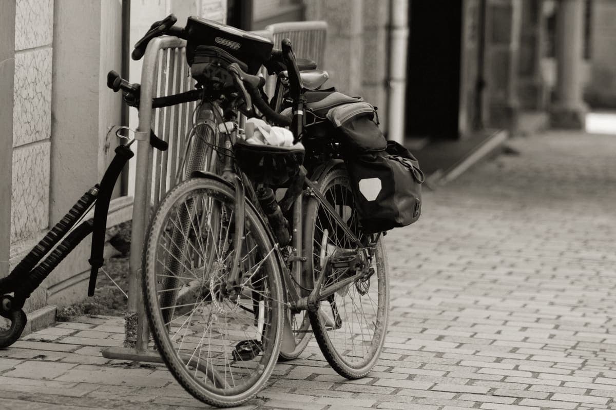 A loaded touring bicycle with panniers parked beside a road