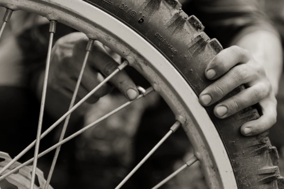 A bicycle wheel rim and tire on a workshop bench